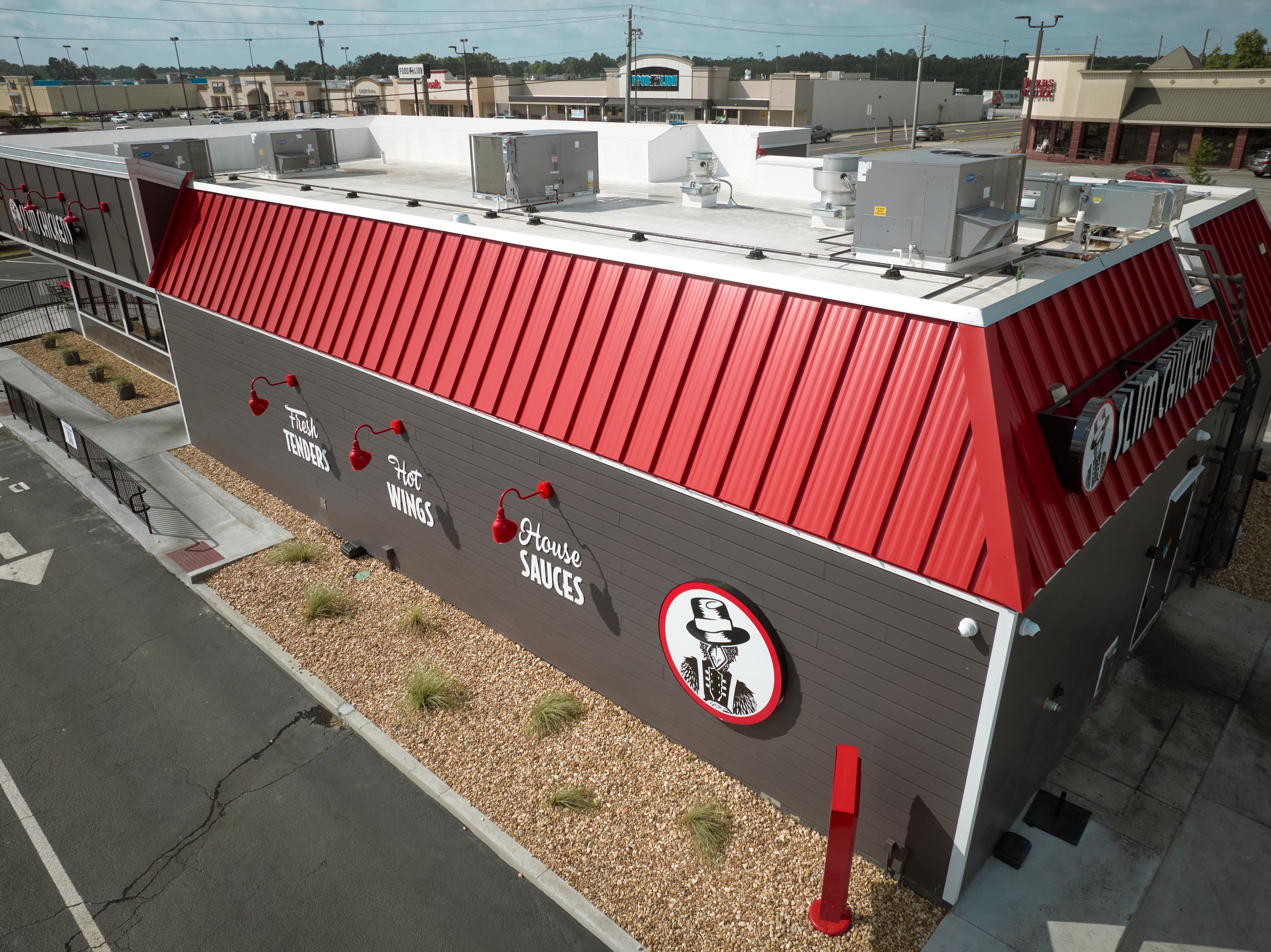 Side-angle drone image of Slim Chickens restaurant's newly-installed commericial roof. HVAC units are also present on the roof.